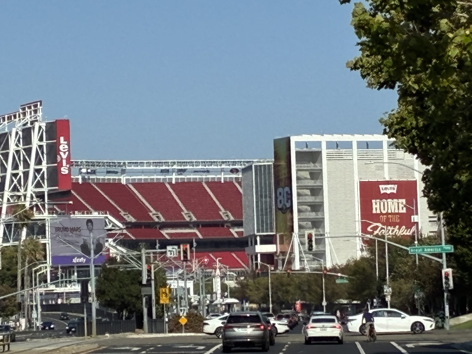 The stadium's main frontage and banner, a few cars waiting at the lights