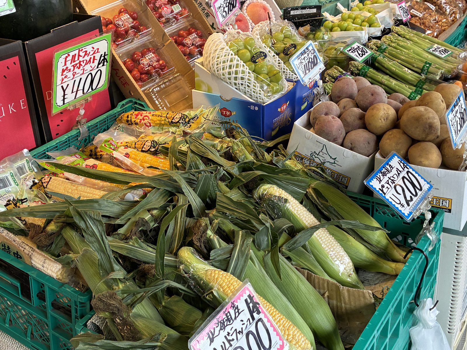 Crates of Hokkaido corn, melons and potatoes at a market stall