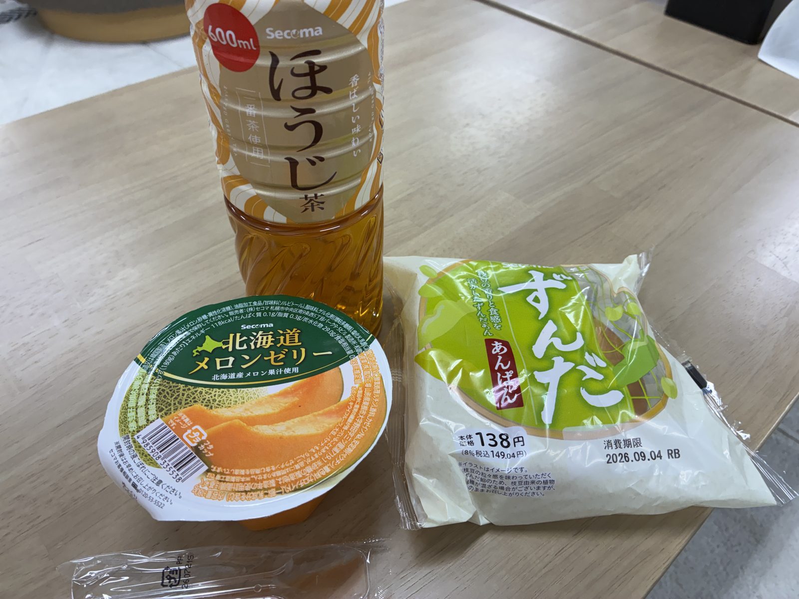 A convenience-store houjicha, a Hokkaido melon jelly and a zunda bun on a table